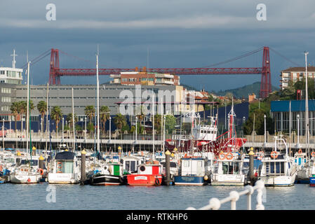 Bilbao in Spanien: Der Hafen von Puerto Pesquero de Santurtzi bei Portugalete, mit der Vizcaya-Brücke über den Fluss Nervion in der Ferne Stockfoto