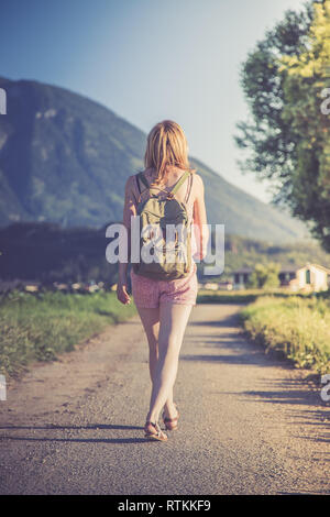 Junge Mädchen in der Overall mit Rucksack ist einen Spaziergang machen, Sommer Stockfoto