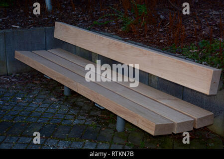 Rustikale Modell eines Massivholz Sitzbank mit Metallfüßen im Außenbereich im Frühjahr keine Menschen, neue Holz- parkbank mit hellen Planken Stockfoto