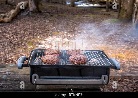 Grillen Burger auf die Holzkohle Grill auf dem Holz Stockfoto