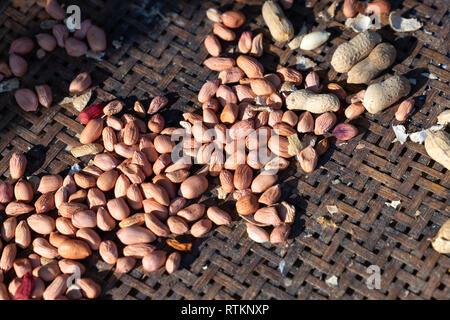 Rohe geschälte Erdnüsse auf alten Bambus Warenkorb Stockfoto