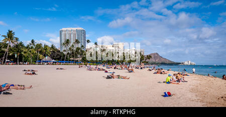 Touristen Sonnenbaden und Surfen am Strand von Waikiki am 26. Juni 2013 in Oahu. Waikiki Beach ist direkt am Strand von Honolulu, am besten bekannt für Weiße Stockfoto