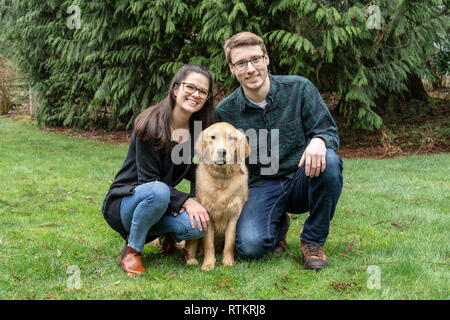 Issaquah, Washington, USA. Porträt eines neun Monate alten Golden Retriever "Aspen" mit seinem Besitzer. (PR) (MR) Stockfoto