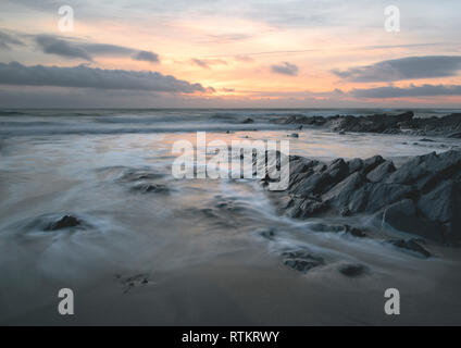 Eine lange Exposition winter Sonnenuntergang am Gunwalloe Church Cove Stockfoto