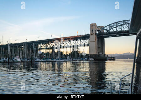 Ein Blick auf False Creek und die Burrard Street Bridge in der Morgendämmerung, von an Bord eines Bootes zu unter der Brücke auf dem Weg zum Meer von Vancouver. Stockfoto