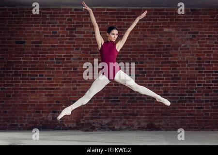 Anmutige Ballerina rot Body springen in die Luft. in voller Länge Foto Stockfoto