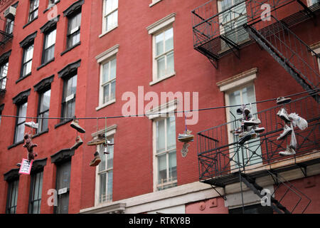 New York City, NY - Februar 06, 2017: Verschiedene Schuhe hängen von einem Telefon kabel in den Straßen von New York City, NY Stockfoto