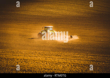 Traktor im Herbst arbeiten in den Bereichen Südmähren bei Sonnenuntergang Stockfoto