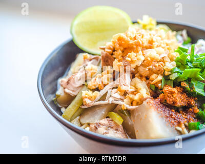 Shred Huhn instant Nudeln mit Knoblauch frittierte. Chili Pulver, Zitrone, Frühlingszwiebel und heiße Suppe mit Gewürzen in eine Schüssel am weißen Tisch Stockfoto