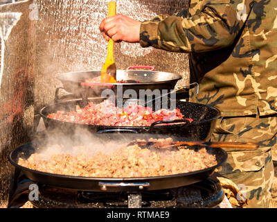 Nicht erkennbare Person kochen traditionelles Essen genannt chichas auf der Straße in einem beliebten Party in einem Dorf in Spanien Stockfoto