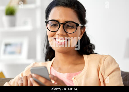 Gerne indische Frau zu Hause verwenden Smartphone Stockfoto