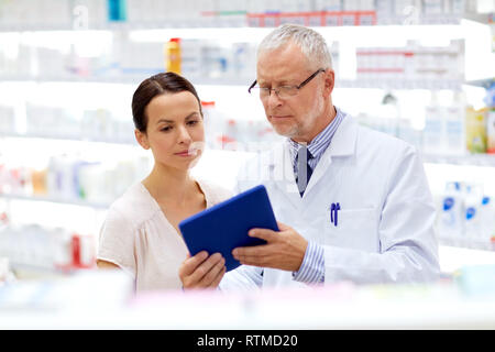 Apotheke und Kunden mit Tablet-PC in der Apotheke Stockfoto