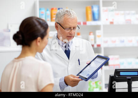 Apotheke und Kunden mit Tablet-PC in der Apotheke Stockfoto