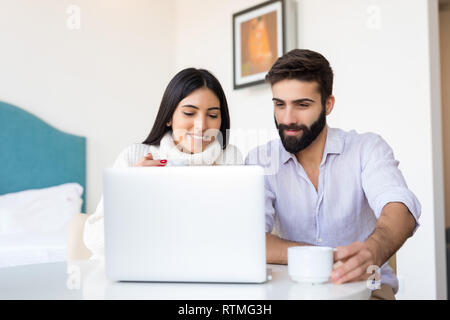 Ein Mann und eine Frau zusammen auf einem Laptop. Sie sind etwas diskutieren für Ihre Wohnung. Sie sind auf der Suche nach etwas Wichtiges auf der Intern Stockfoto