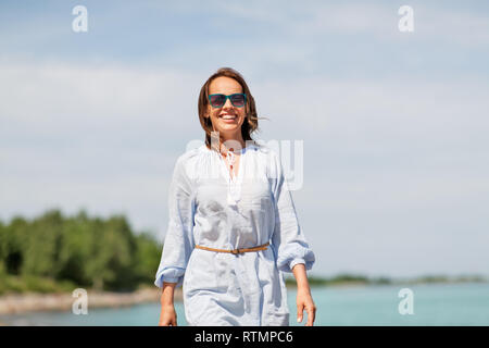 Glücklich lächelnde Frau entlang Sommer Strand Stockfoto