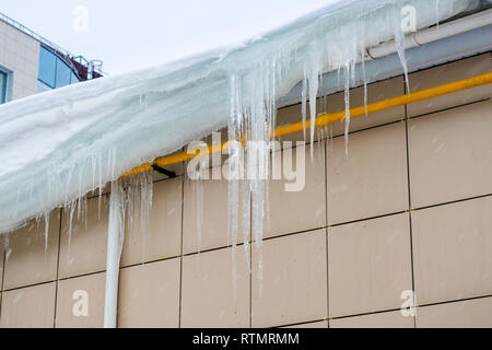 Große Eiszapfen hängen von der Decke. Gefahr für Passanten. Stockfoto