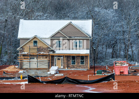 Horizontale Schuß eines Winter zwei - Geschichte Home Baustelle. Es gibt Schnee auf dem Dach und die Bäume hinter dem Haus im Bau. Stockfoto