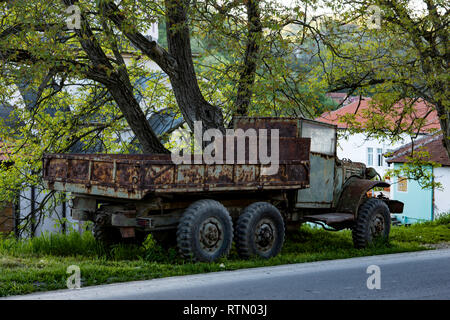 Eine alte verlassene Militär-LKW, Links zu verrotten im Gras, aber gegen den Zahn der Zeit, große Räder und korrosive Metall. Serbien Stockfoto