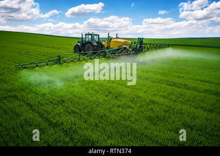 Luftaufnahme von landwirtschaftlichen Traktor Pflügen und Spritzen auf dem Feld. Stockfoto