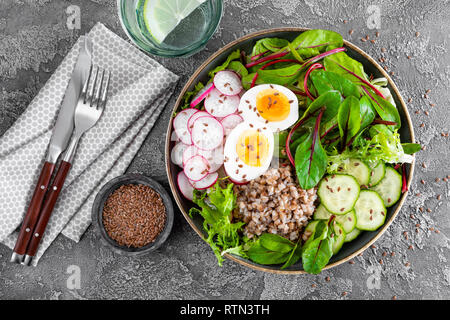 Buddha Schüssel Schüssel mit Buchweizen Brei, gekochte Eier, frisches Gemüse Salat, Radieschen, Gurken, Salat und Mangold verlässt. Gesundes Mittagessen Menü. Top vie Stockfoto