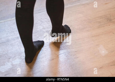 Person zu Fuß auf Holzboden Strümpfe tragen Stockfoto