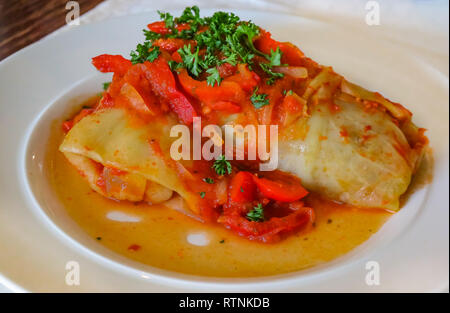 Traditionelle russische Kohlrouladen, gefüllt mit Hackfleisch in Tomatensoße gekocht und auf einer Platte mit Petersilie bestreut serviert in einem Restaurant in Rus Stockfoto