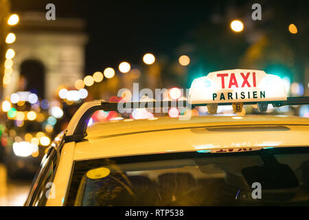 Französische Taxi mit den Champs-Elysées im Hintergrund Stockfoto