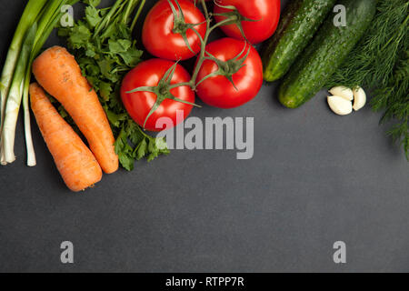 Anordnung der gemischten bunten Gemüse, auf dunkelgrau Schiefer Hintergrund mit leeren Raum isoliert. Banner kopieren Stockfoto