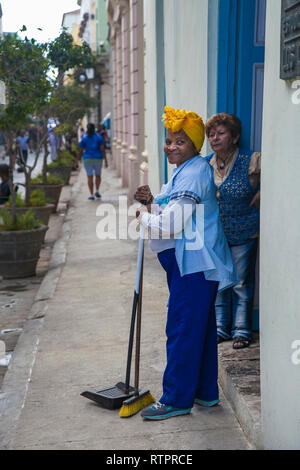 Havanna, Kuba - 22. Januar 2013: Ein Blick auf die Straßen der Stadt mit dem kubanischen Volk. Eine Putzfrau im Gespräch mit dem Bewohner des Hauses. Stockfoto