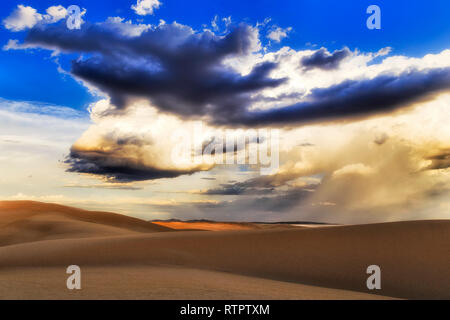 Trockene verlassene Sanddünen am Stockton Beach von Australien bei stürmischem Wetter mit riesigen Strukturierte cloud Massen in den Himmel. Stockfoto