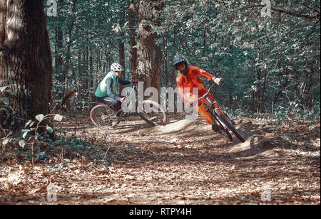 Moskau, Russland - Nov, 2018: MTB-Lehrer helfen Reiter lernen, Fahrrad zu fahren. Lehre ein Reiter, ein Fahrrad auf einem Trail zu fahren. Zwei Freunde haben Spaß in der Natu Stockfoto