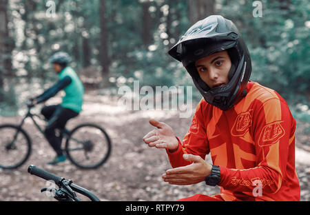 Moskau, Russland - Nov, 2018: MTB-Lehrer helfen Reiter lernen, Fahrrad zu fahren. Lehre ein Reiter, ein Fahrrad auf einem Trail zu fahren. Zwei Freunde haben Spaß in der Natu Stockfoto