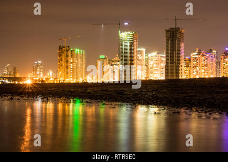 Eine schöne Aufnahme der Stadt Netanya in Israel während der Nacht. Die hellen Lichter der Stadt auf dem Wasser am Strand nieder. Stockfoto