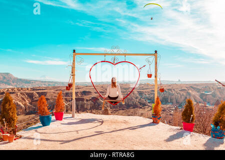 Sorglos Frau auf der Schaukel. Inspirierende Bergwelt. Traum und Freiheit Konzept. Stockfoto