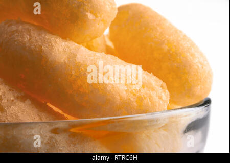 Luftig, Chips, Corn Puffs, Puffcorn Snacks in einer Glasschale mit transparentem Hintergrund. Crunchy aromatisiert aufgeblasen Bereit zu Essen behandelt. Party, Kino, TV, G Stockfoto