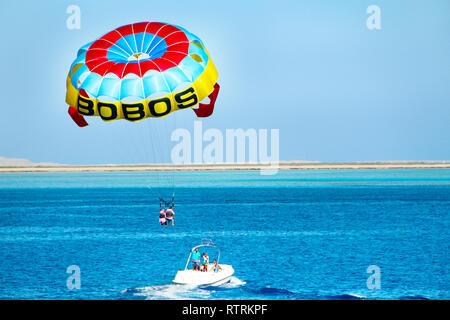 Der Mensch ist gern Parasailing über das Rote Meer. Tropical Resort in Ägypten. Menschen Ruhe auf ägyptischen Resort. Travel Concept. Fliegen am Fallschirm hinter dem Boot auf Stockfoto