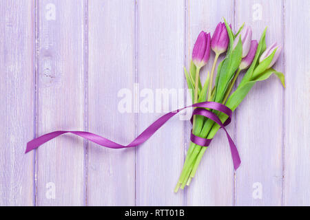 Lila Tulpen Strauß auf Holztisch. Ansicht von oben mit Platz für Ihren Text Stockfoto