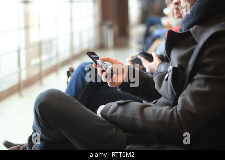 Bis zu schließen. Der moderne Mensch mit Smartphone in Flughafen Gebäude Stockfoto