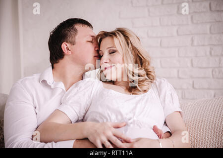 Glücklich Mann seine schwangere Frau glücklich Küssen. Stockfoto