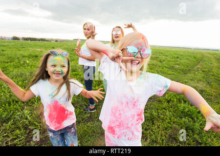 Urlaub, festival Holi und Freundschaft Konzept - Porträt der glücklichen Frauen und Kinder in Farbe bedeckt Stockfoto