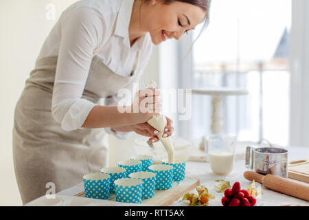 Asiatische Mädchen Gießen Teig in das Papier kochen Messer, Nahaufnahme, Seite, Ansicht Foto. Kopieren Sie Platz Stockfoto