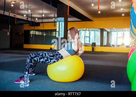 Aufnahme der jungen Frau trainieren im Fitnessstudio. Muskulöse Frauen Training mit einem Ball. Frau tun, Sit-ups in den Morgen. Stockfoto