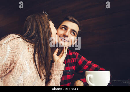 Junge Frau küsst ihr Freund in der Backe im Cafe. Romantisches Frühstück Stockfoto