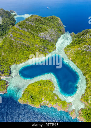Luftaufnahme von einem entfernten Satz von Kalkstein Inseln mit einer herzförmigen, natürlichen Lagune, den Raja Ampat Inseln, West Papua, Indonesien, Pazifischer Ozean Stockfoto