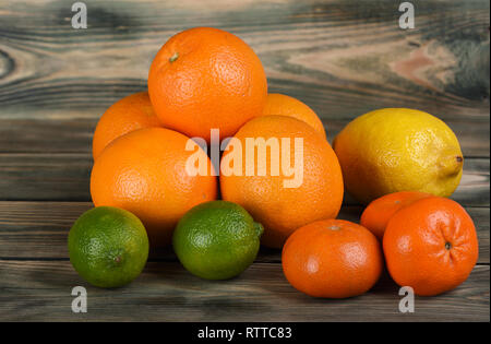 Citrus Platte mit Orangen, Mandarinen, Zitronen und Limetten auf einem Holztisch. Nahaufnahme Stockfoto
