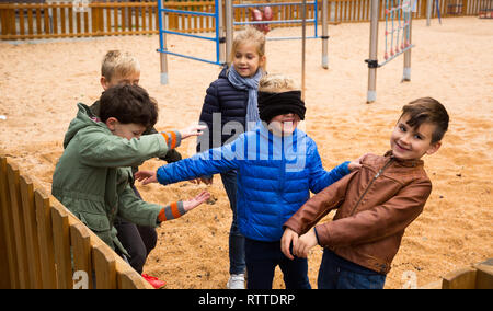 Kinder spielen in Buff des blinden Mann Stockfoto