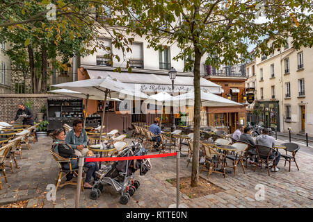 Ein Paar mit einem Baby Entspannen an einen Tisch draußen Restaurant Le Relais De La Butte, während ein Kellner nimmt einen Auftrag, ein Restaurant in Montmartre, Paris Stockfoto