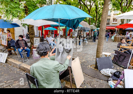 Ein Künstler bei der Arbeit skizziert ein Porträt einer Frau auf dem Place Du Tetre, einem beliebten Platz in Montmartre, Paris, Frankreich Stockfoto