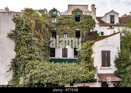 Efeu wächst an der Wand eines Hauses in Montmartre, die Häuser der Le Troubadour Restaurant Cafe, Paris, Frankreich Stockfoto