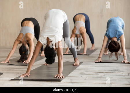 Gruppe von Menschen üben Yoga Lektion, Adho Mukha Svanasana Übung Stockfoto